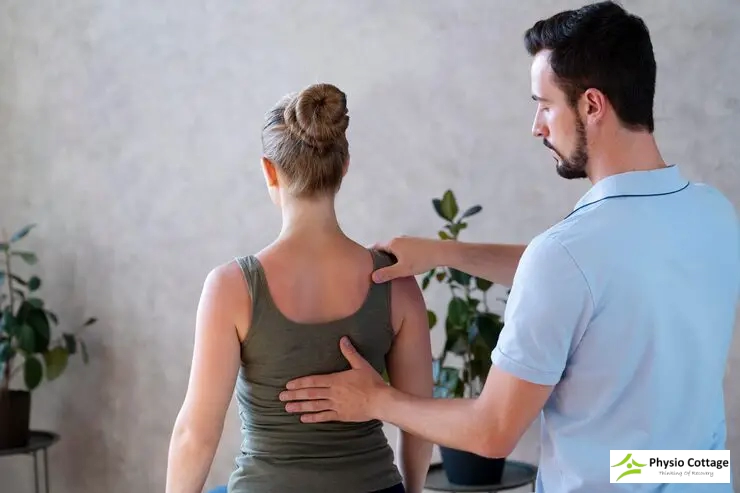 Chiropractor assesses a patient's upper back and shoulder alignment during consultation.