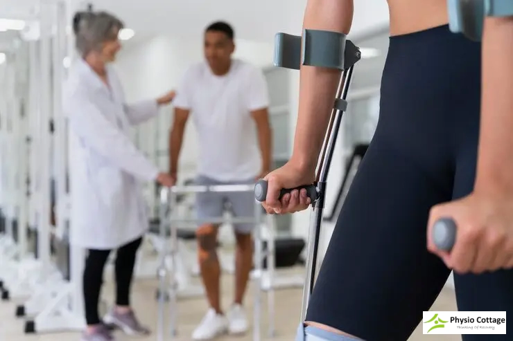 A blurred view of a physiotherapist and a male patient using a walker in the background.